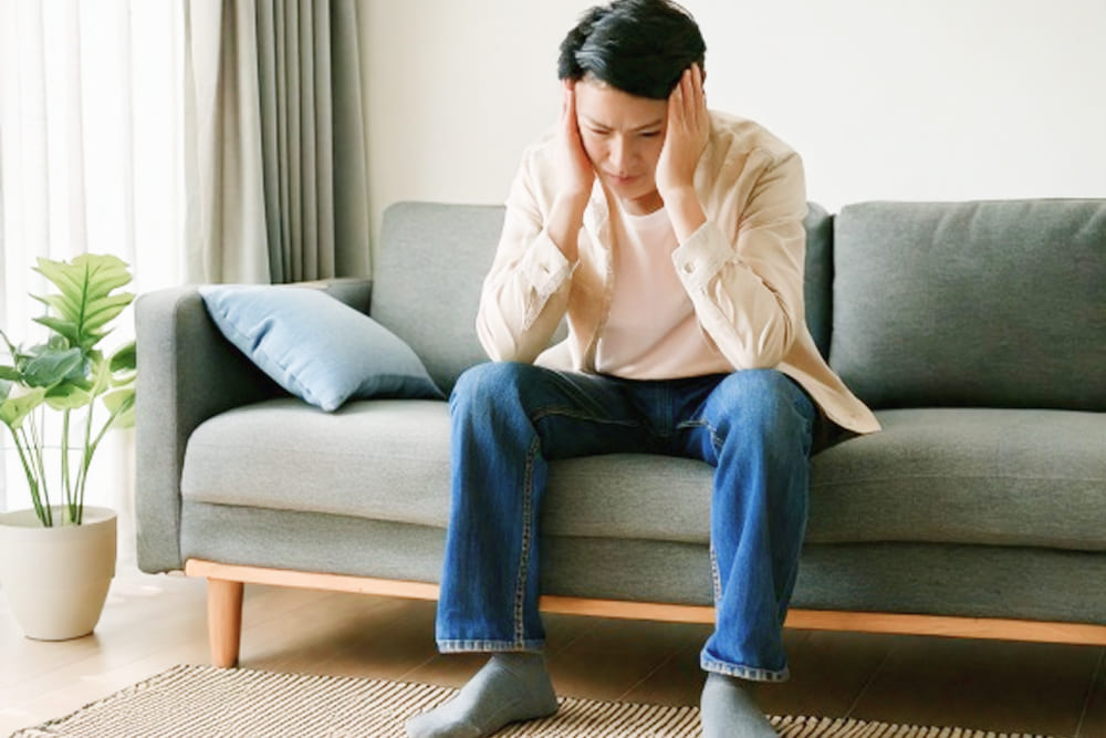頭痛や眩暈に苦しむ男性